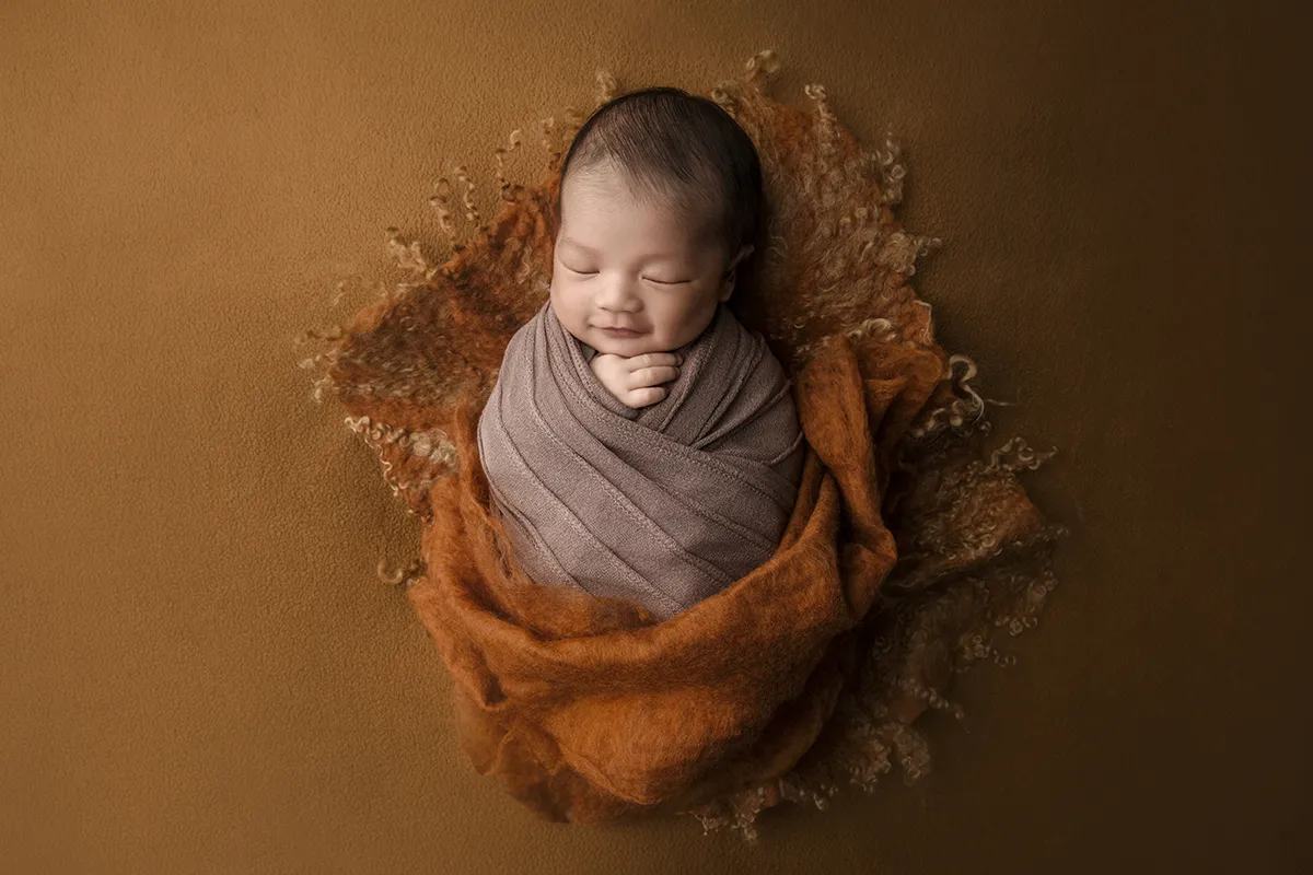 Wrapped newborn baby portrait photographed at Photo Hive studio in Auckland